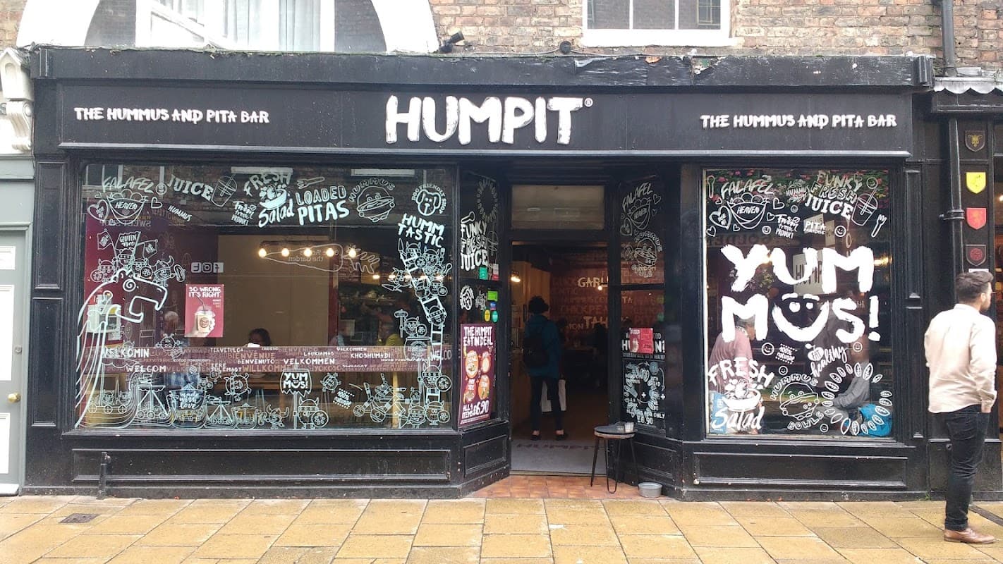 Charming bakery storefront with large windows, colorful signage, and a welcoming atmosphere in York, Yorkshire.