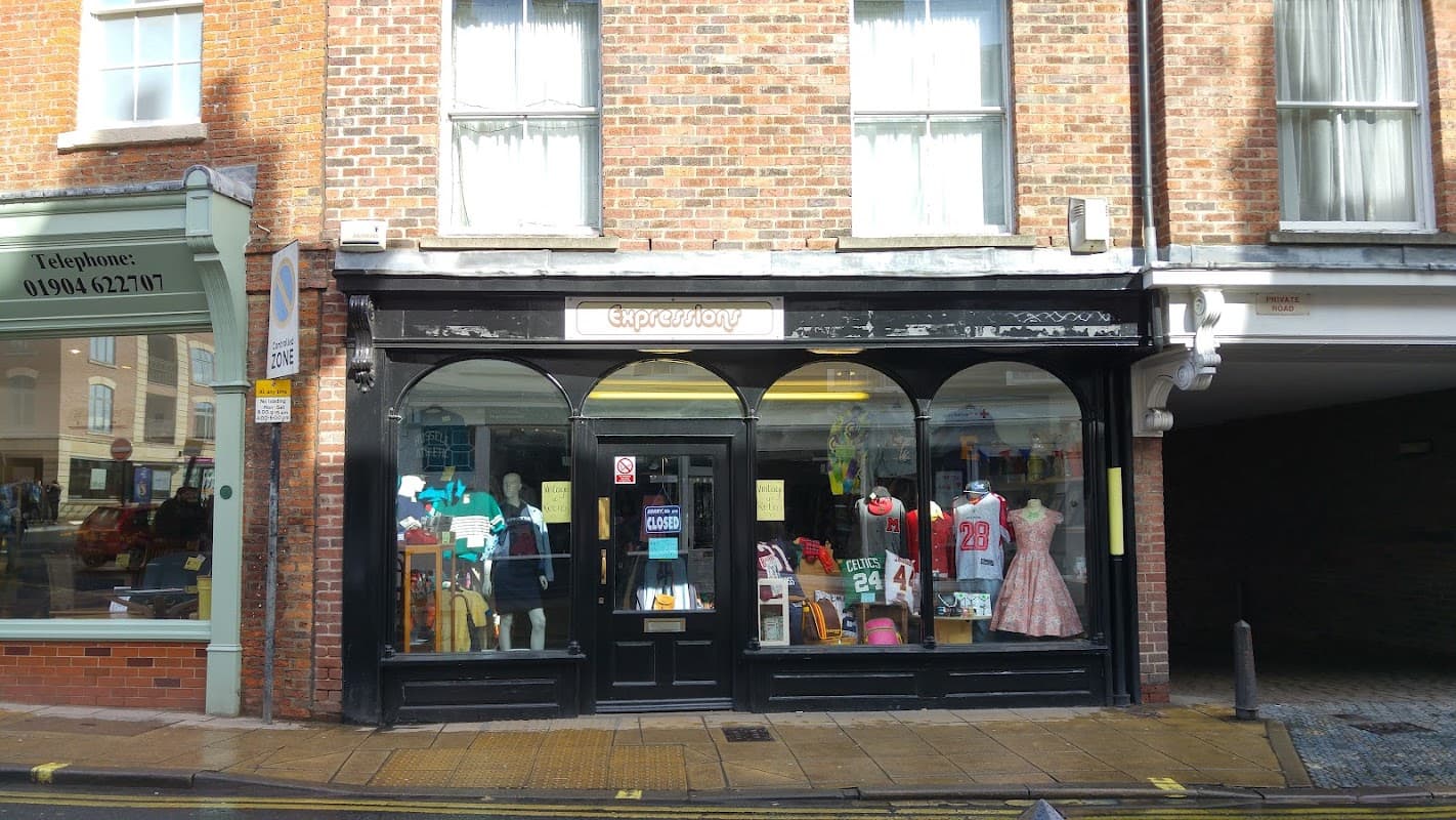 Clothes shop "Expressions" with colorful displays, mannequins, and signage, set in a brick building in York.