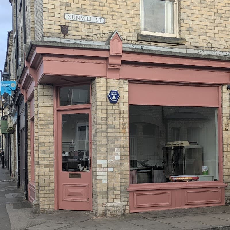Pink storefront of Flori Bakery on Nunmill Street, featuring large windows and a charming brick facade.