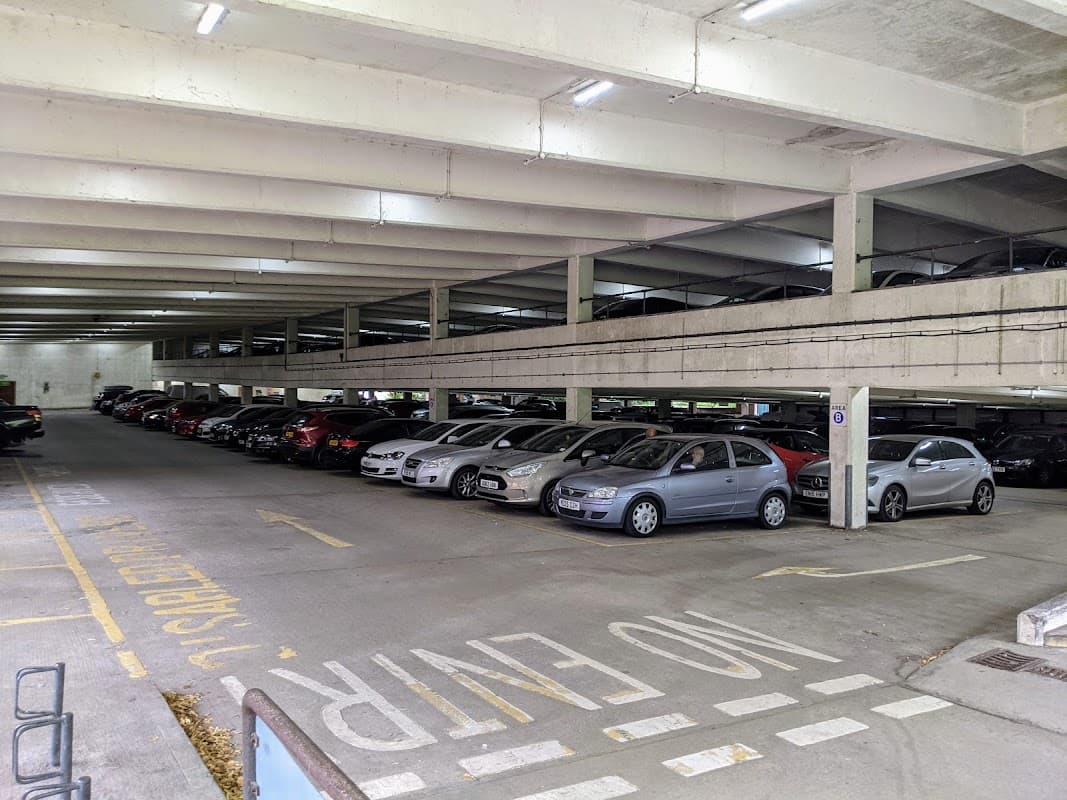 Multi-level car park with parked vehicles, concrete structure, and clear signage indicating "No Entry."