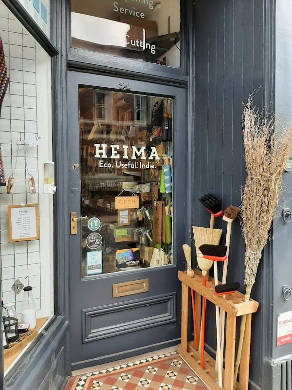 Storefront of HEIMA, featuring eco-friendly homeware, brushes, and a welcoming "OPEN" sign.