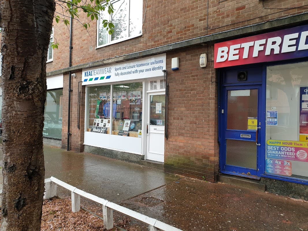 Keal Teamwear storefront with sports uniforms displayed, next to a Betfred shop in York, Yorkshire.