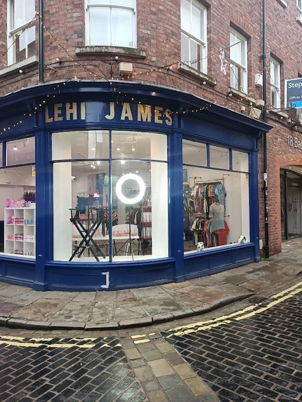 Lehi James Limited storefront with blue trim, displays sports gear, and a circular light in the window.