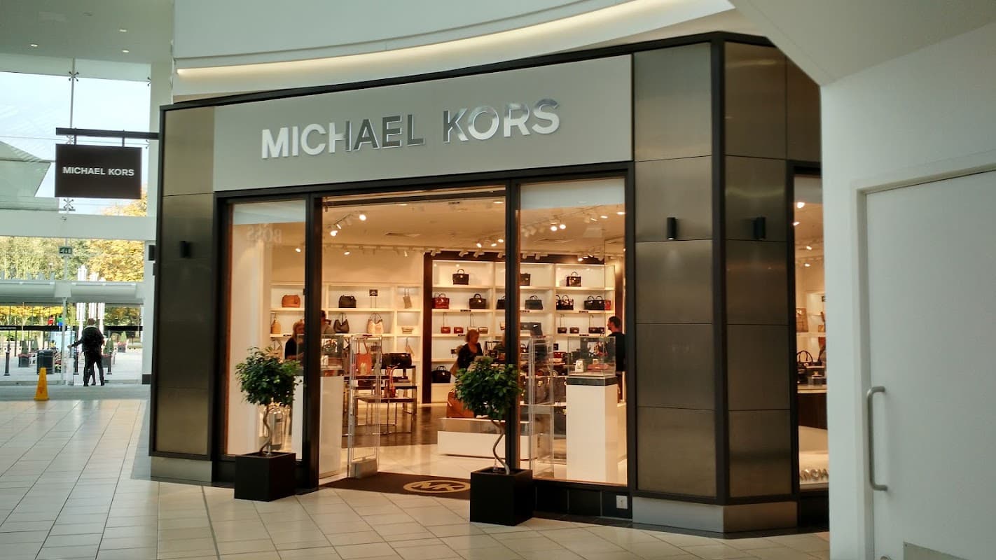 Michael Kors outlet storefront featuring bags and accessories, with a modern design and glass entrance.