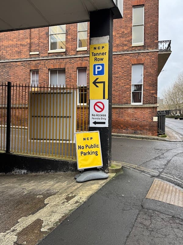 Signage indicating parking rules at NCP Tanner Row, with a brick building and a no public parking sign visible.