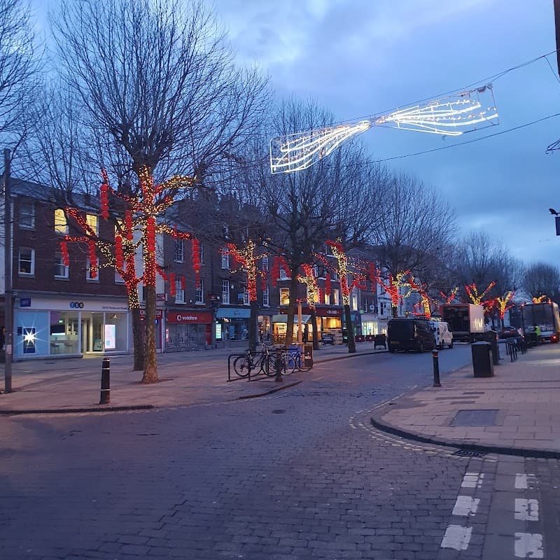 Cycle parking area on Parliament St. South, with festive lights on trees and shops lining the street.