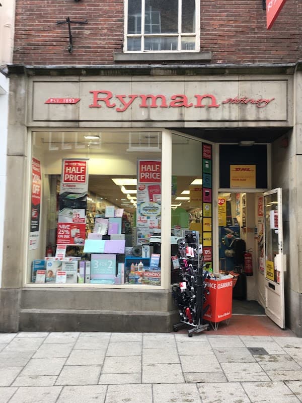Ryman Stationery storefront with promotional signs, displaying stationery items and a clearance rack outside.