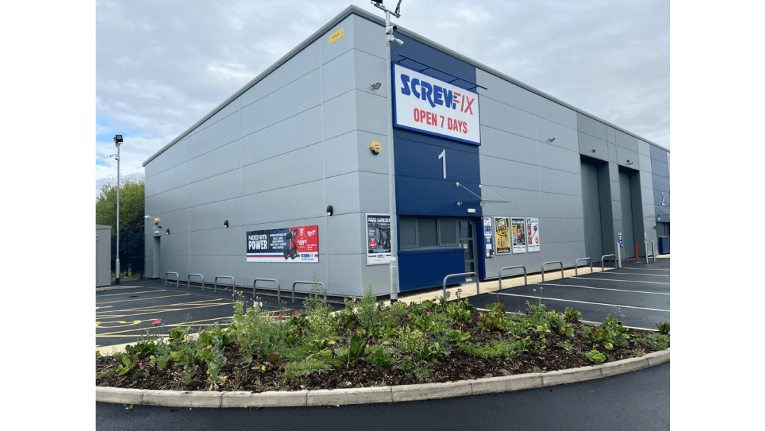 Screwfix store exterior with signage, parking lot, and landscaped area in front, located in Monks Cross, York.