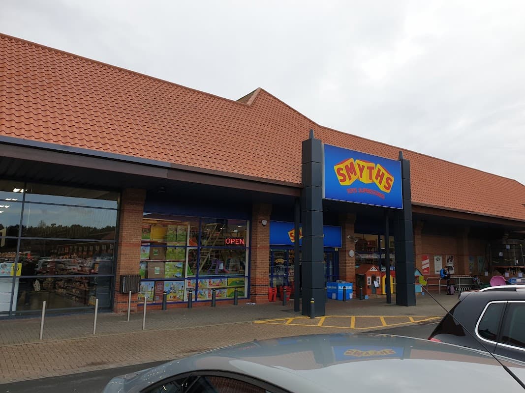Smyths Toys Superstores storefront with a red and yellow sign, open entrance, and shoppers outside in York.