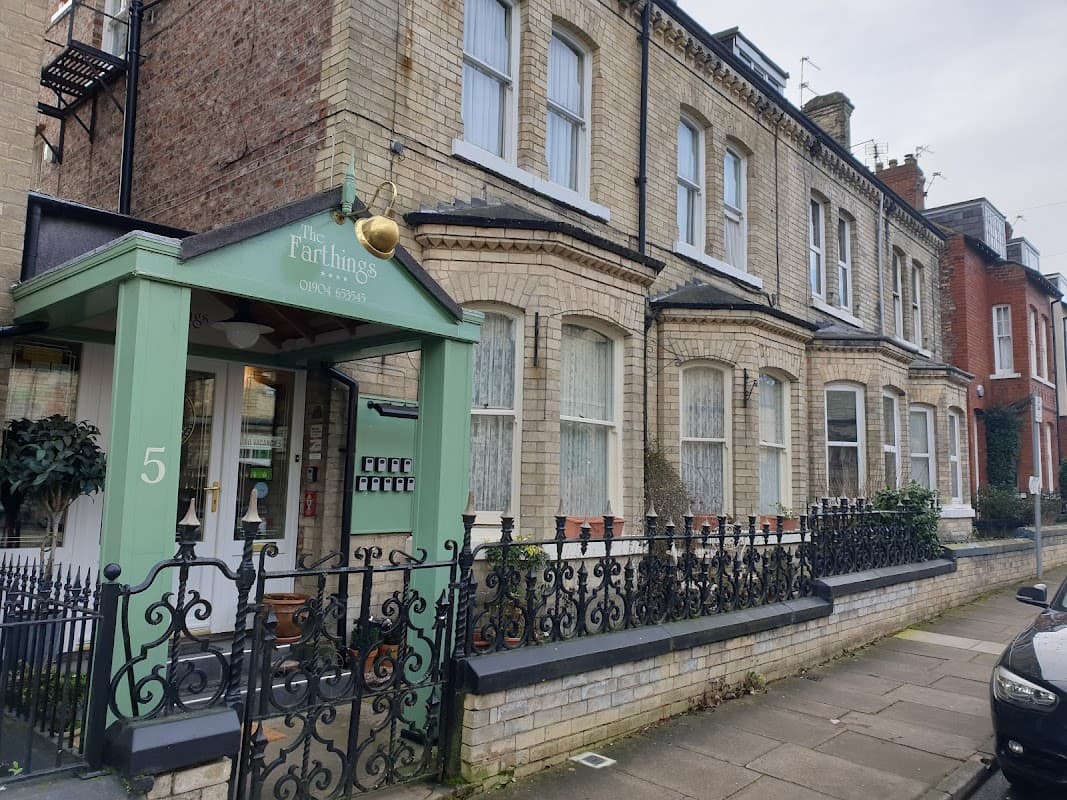 Victorian-style guest house with green entrance, wrought iron fence, and large windows in York, Yorkshire.