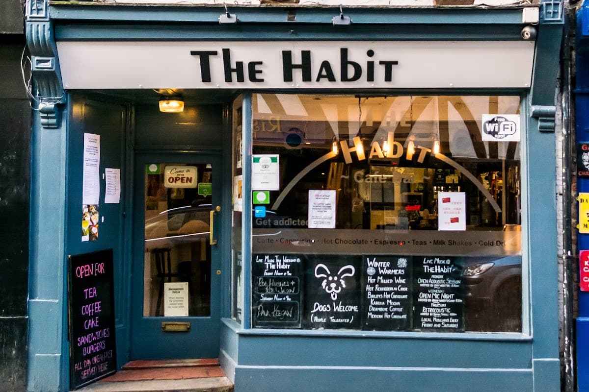 Exterior view of The Habit Cafe Bar with a welcoming entrance, menu boards, and colorful signage in York, Yorkshire.