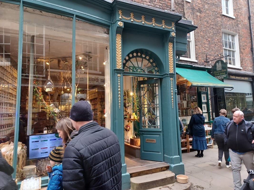 Quaint bookshop entrance with green door, large windows, and people browsing outside in a charming York street.