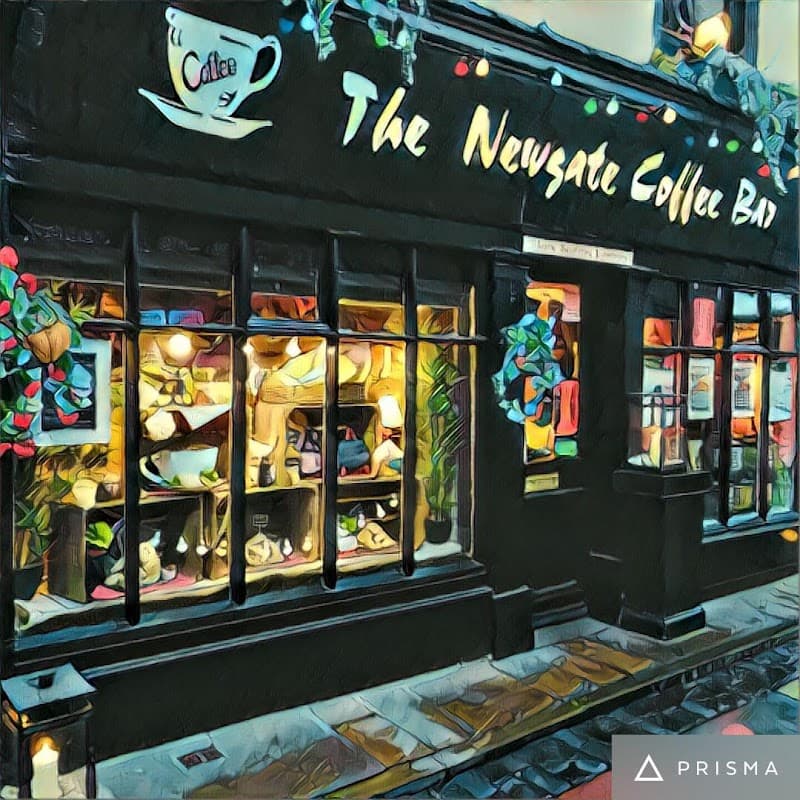 Charming cafe exterior with a sign, colorful window displays, and decorative plants in York, Yorkshire.