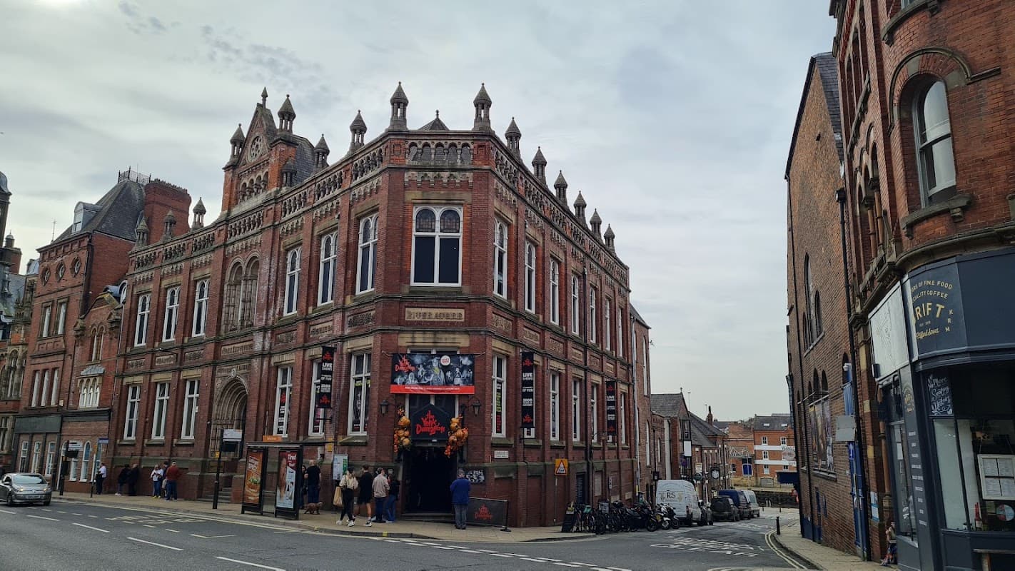 Victorian-style building with ornate architecture, featuring banners and a busy street scene in York, Yorkshire.