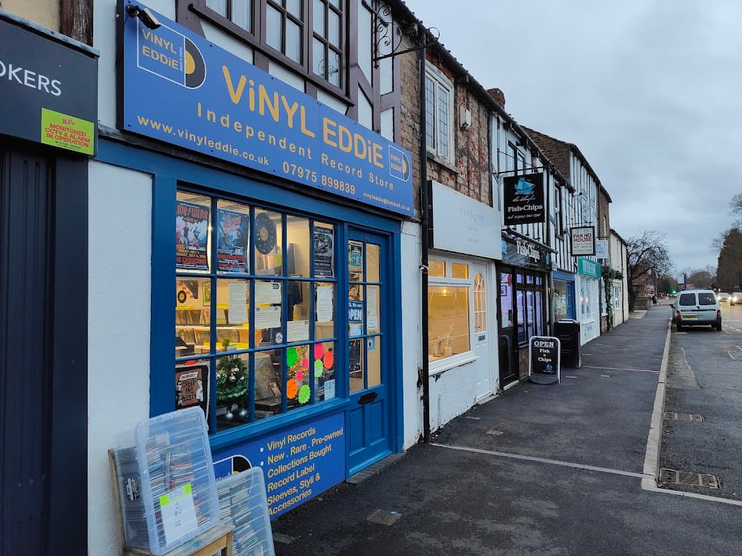 Vinyl Eddie store front with blue signage, displaying records and music-related items in a quaint York street.