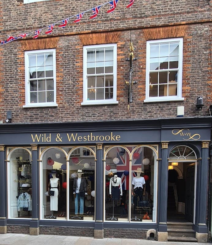 Clothing shop exterior with large windows, Union Jack bunting, and stylish outfits displayed in York, Yorkshire.