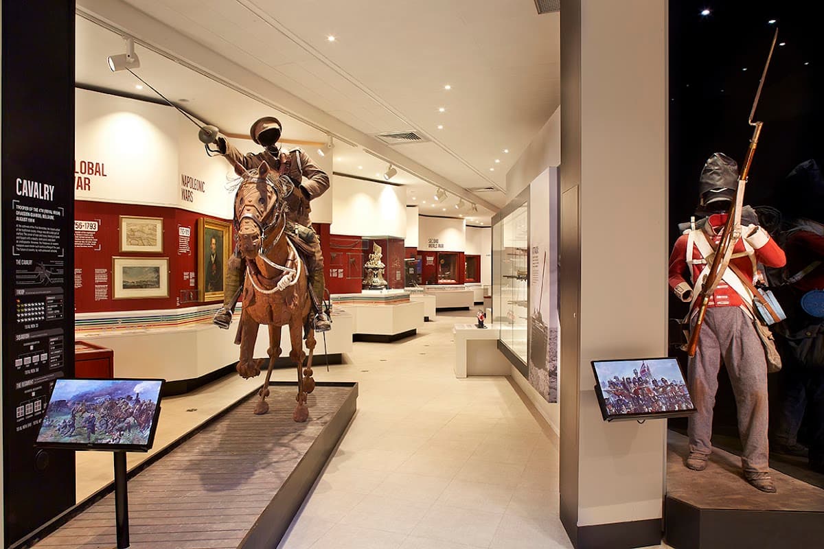 Cavalry exhibit featuring a mounted soldier and a standing infantryman, with historical displays in the background.