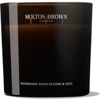 Black Molton Brown candle with white text, labeled "Oudh Accord & Gold," in a sleek, cylindrical glass container.