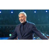 I don't know who this is, but it appears to be a man in a blue plaid suit on stage with a microphone.