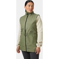 Green Helly Hansen women's spring vest with front zipper, high collar, and drawstring waist, worn over beige sleeves.