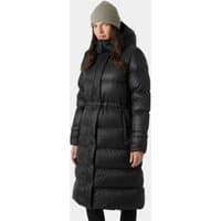 Black Helly Hansen women's long down coat with hood, quilted design, and waist cinch, worn by model in gray beanie.
