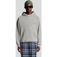 Light grey marl pullover hoodie with kangaroo pocket and small embroidered logo, worn by a model in plaid pants.