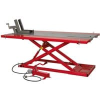 Red Sealey foot pedal motorcycle hydraulic lift with black platform and crisscross support, 680kg capacity.