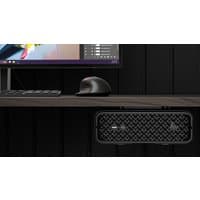 Compact black HP Z2 Mini desktop with textured front panel, placed under a desk with a monitor and mouse on top.