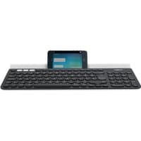Black Logitech K780 wireless keyboard with round keys and integrated device stand holding a smartphone.