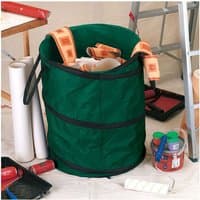Green Draper pop-up tidy bag, 175L, with black handles, filled with tools and paint supplies, set in a workshop.