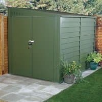 Green metal shed with double doors, horizontal paneling, and a sloped roof, set on a stone patio.