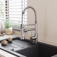 Stainless steel kitchen faucet with pull-down spring spout and pot filler, sleek design over a black sink.