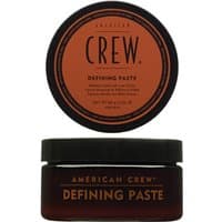 Brown jar with black lid, labeled "American Crew Defining Paste," featuring orange circular label on top.