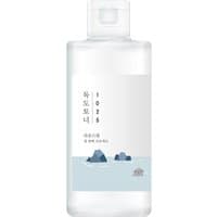 Clear Round Lab toner bottle with minimalist label, featuring blue ocean and island illustration.