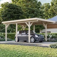 Wooden carport with flat roof, natural finish, supported by sturdy beams, fits one car, surrounded by greenery.