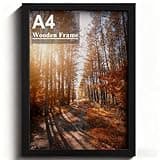 A4 black wooden photo frame with safe Perspex front, wall hanging hooks, displaying autumn forest path image.