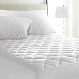 White quilted microfiber mattress protector on double bed with extra deep 30 cm fit, anti-allergy feature.