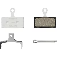 Shimano G05A-RX resin disc brake pads with silver alloy backing, spring, and pin, featuring textured braking surface.