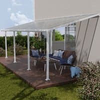 White Palram Canopia patio cover with clear panels, supported by white posts, over a wooden deck with outdoor furniture.