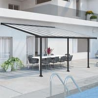 Grey Palram Canopia patio cover with clear panels, supported by black frame, over outdoor dining area.