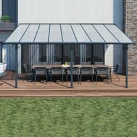 Grey Palram Canopia Sierra patio cover with clear panels and metal frame over outdoor dining set on wooden deck.