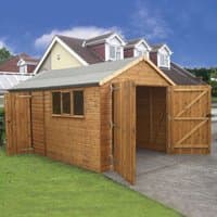 Wooden garage shed with double doors, shiplap cladding, and side window, set on a concrete base.