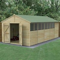 Wooden shed with green apex roof, double doors, shiplap cladding, and multiple windows, set in a grassy area.