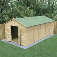 Windowless wooden apex shed, 20' x 10', with double doors, green roof, tongue and groove panels, set on a concrete base.