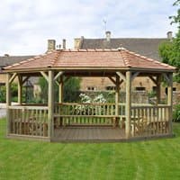 Oval wooden garden gazebo with cedar roof, open sides, and seating for 27 on a grassy lawn.