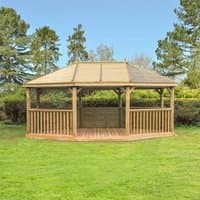 Wooden garden gazebo with timber roof, open sides, and seating for 27, set on a grassy lawn with trees in the background.