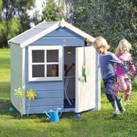 Blue and white wooden playhouse with a pitched roof, window, and open door, set in a grassy area with children playing nearby.