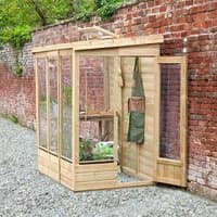 Wooden lean-to greenhouse with glass panels, solid back, and door, set against a brick wall.