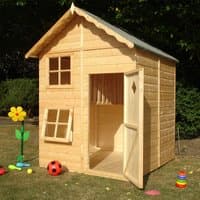Wooden garden playhouse with pitched roof, two windows, and open door, surrounded by toys on grass.