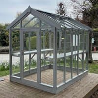 Greenhouse with gray-painted wooden frame, clear glass panels, and apex roof, measuring 5'3 x 9'4 by Coppice.